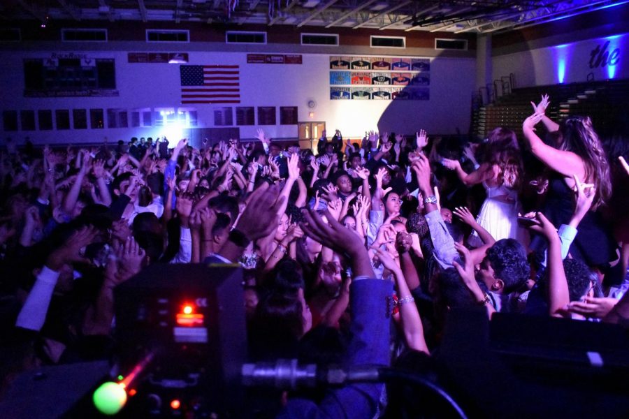 Waving their hands, homecoming-goers dance along to Miley Cyrus’ “Party in the U.S.A.” 
