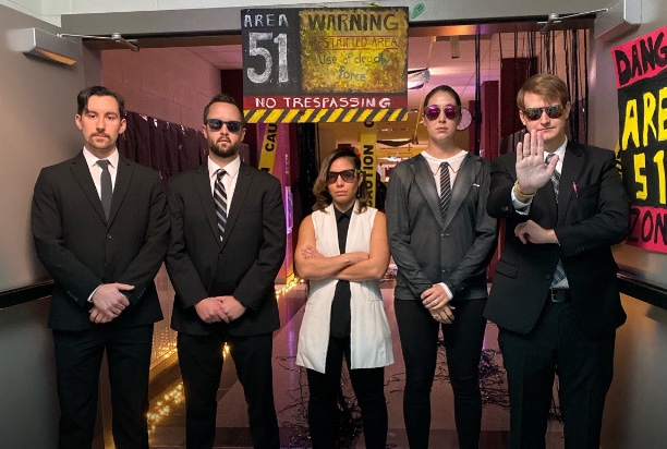 English teachers Sean Heron, Tyler Anderson, Johanna Ayala-Walsh, Shelby Whittington, and Samuel McClain dress up with the theme of “Men in Black” for Space out day. McClain held out his hand to keep anyone from entering Area 51. 
