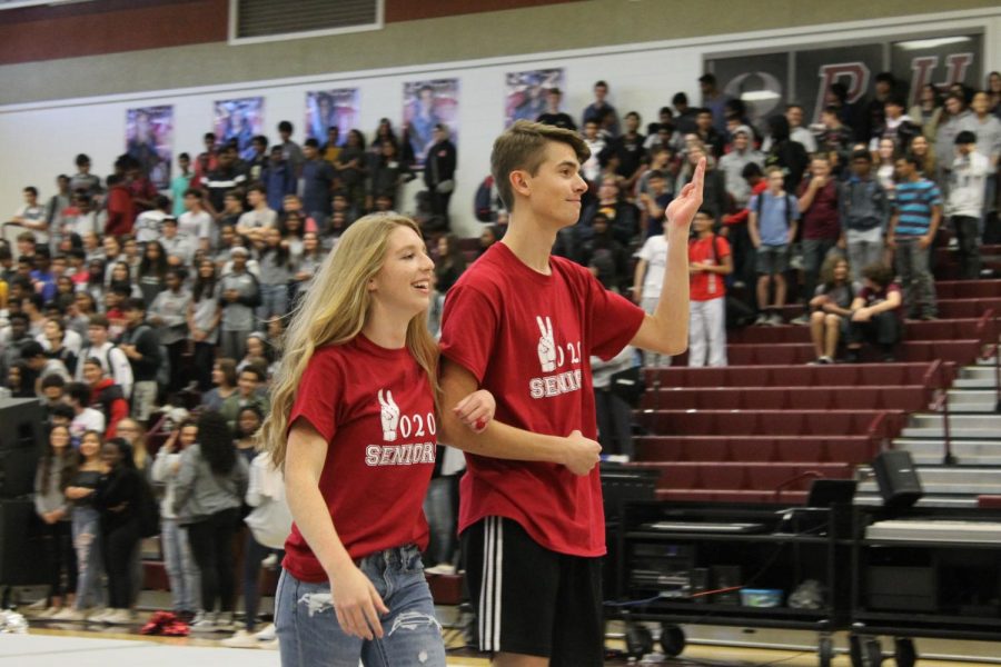 Seniors Chris Canfield and Kendra Yetter wave to the crowd at the Homecoming pep rally. Canfield and Yetter were voted onto the Homecoming court by peers for the class of 2020. “It was fun to represent the senior class and all my friends who voted for me,” Yetter said.