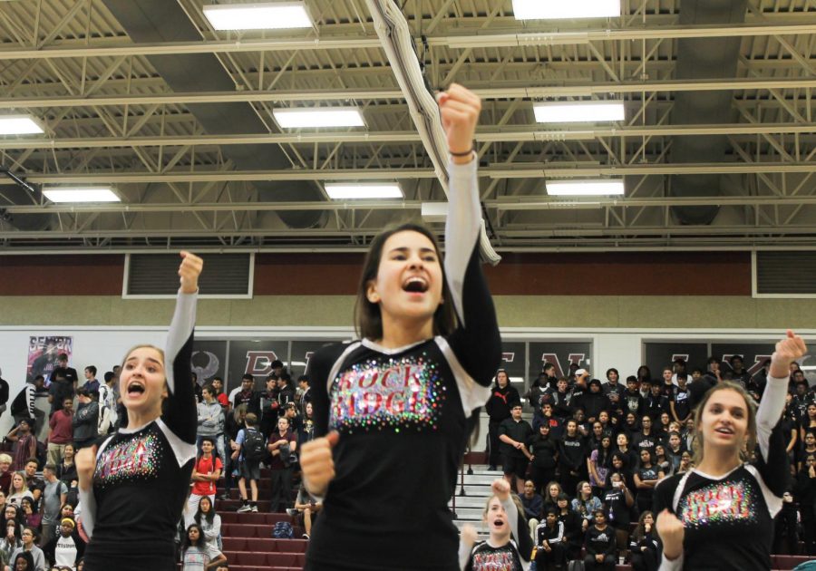 Freshman Elise Irvin, junior Nicki Oberoi, and sophomore Tatiana Conrow (left to right) cheer at the Homecoming pep rally on October 11. The varsity cheerleaders performed with their teammates to get students ready for the Homecoming game later that night. “It was really cool to cheer at the pep rally because we could hear people saying our cheers with us,” Oberoi said.