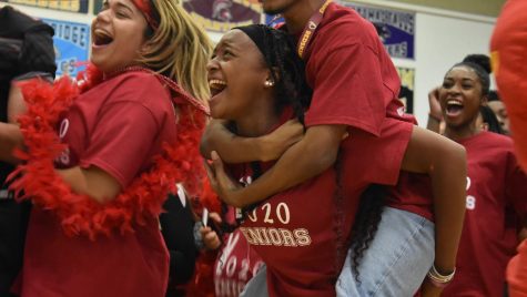 Senior Kayla Davis screams with senior Jordan Cox on her back during the pep rally. Davis was participating with other seniors in the class cheer of the pep rally.