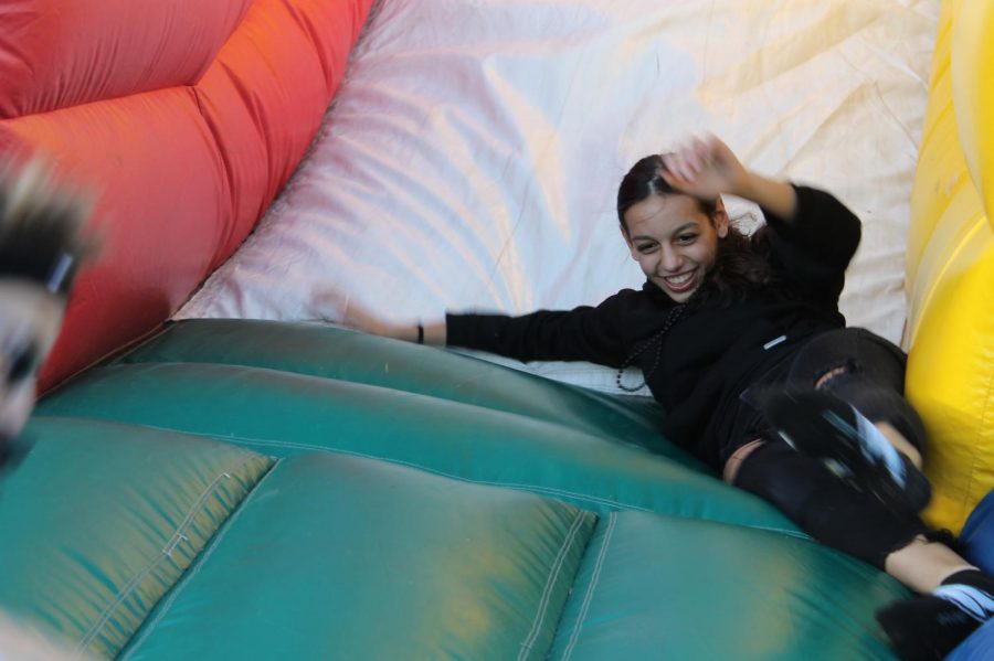 Freshman Julia Freeman slides into the bouncy obstacle course at the tailgate, which was sponsored by SCA. 
