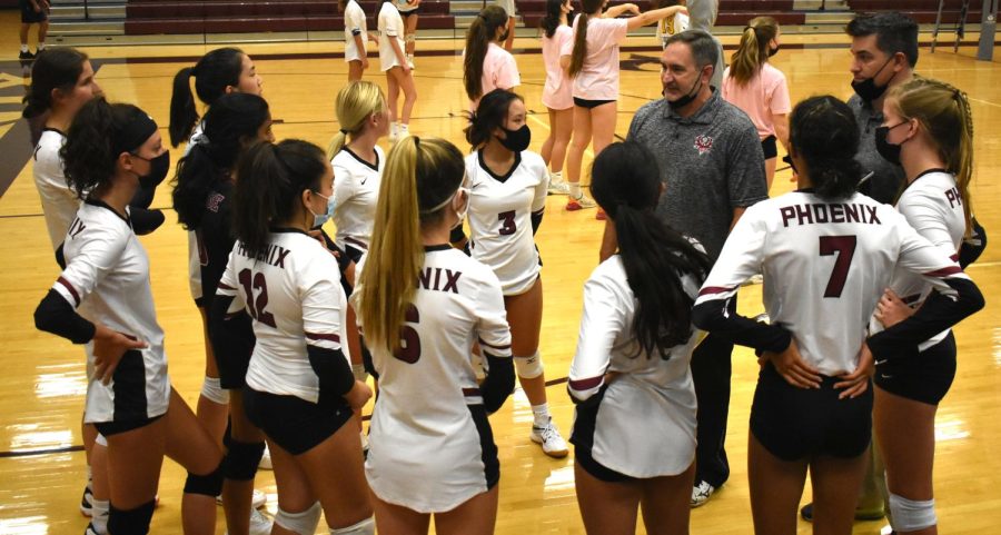 Phoenix varsity volleyball team discusses the game plan with their coaches as they prepare to take on the Captains.