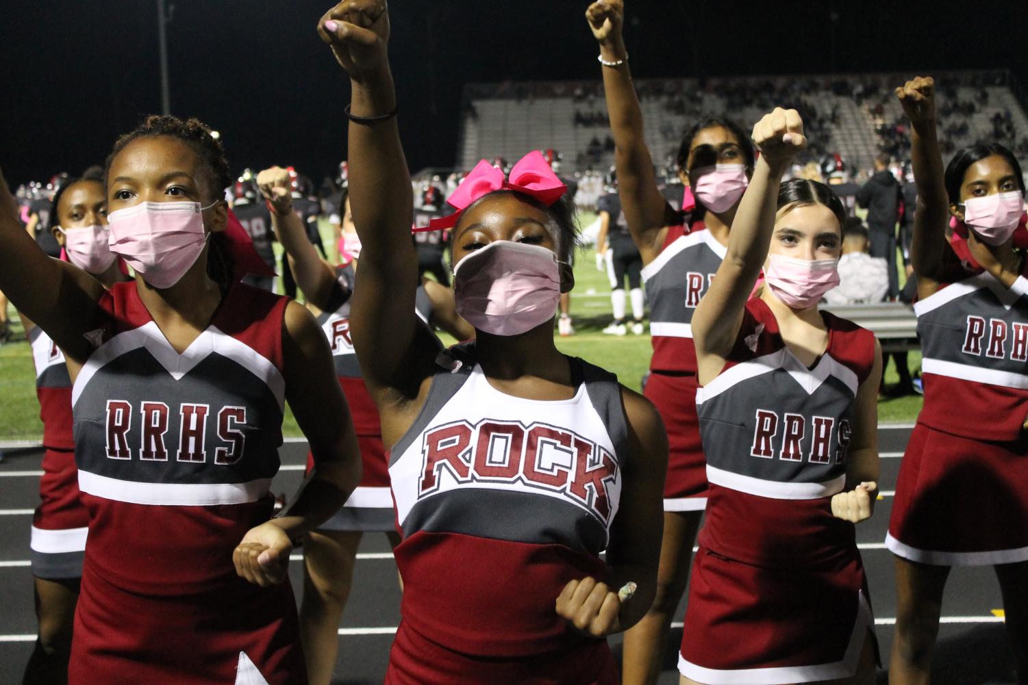 Phoenix cheerleaders lead the “go go, fight fight” chant in front of the student section to bring hype up the fans at the Pink Out game on Oct. 15. Freshman Jaden Thomas, sophomore Caitlynn Washington, and freshman Abby Welch stand in the front to lead the chant. The cheerleaders had pink bows in their hair for the pink out game.