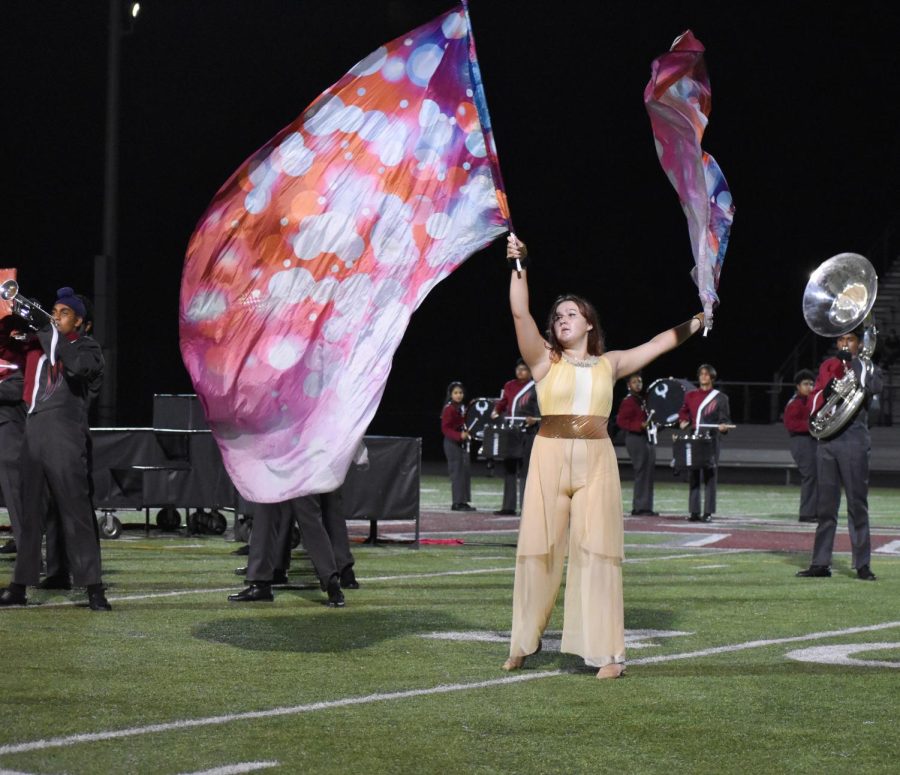 During the halftime show, senior Katie Chepalis waves her flag in the air. The game against the  Parkview Patriots on Oct. 8 ended in a win for the Phoenix, 35-0.