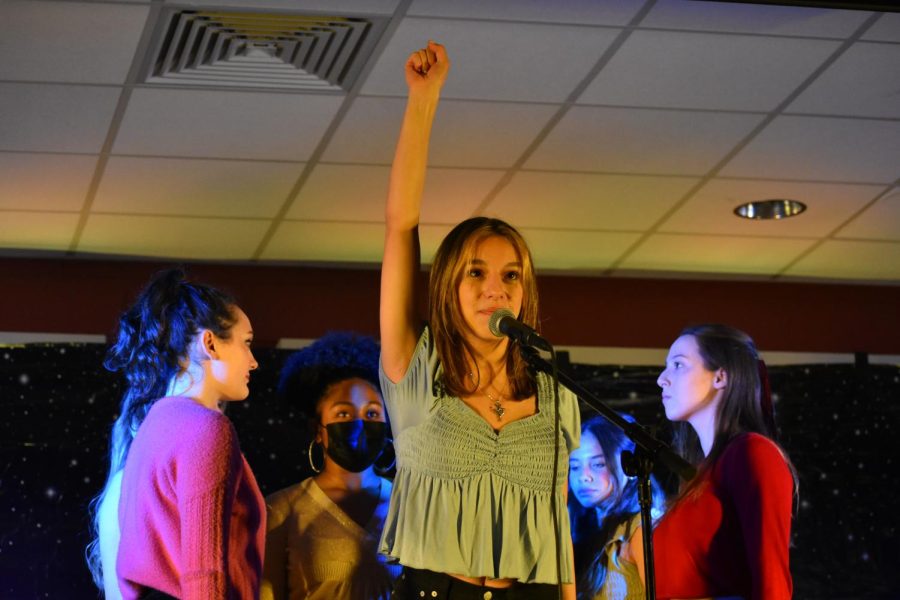 In the final song of Act One at Broadway Desserts, junior Julia Freeman raises her fist while singing “Ex-Wives” from “Six,” accompanied by senior Maddie Kesler, junior D’Amora Brunson, and sophomores Mariah Waters and Kaia Greene, as well as junior Mary Kate Connor (not pictured). “We chose [“Ex-Wives”] since we wanted to do a group project. We usually only do individual projects, and we thought it would be fun to come together and perform it,” junior D’Amora Brunson said. 