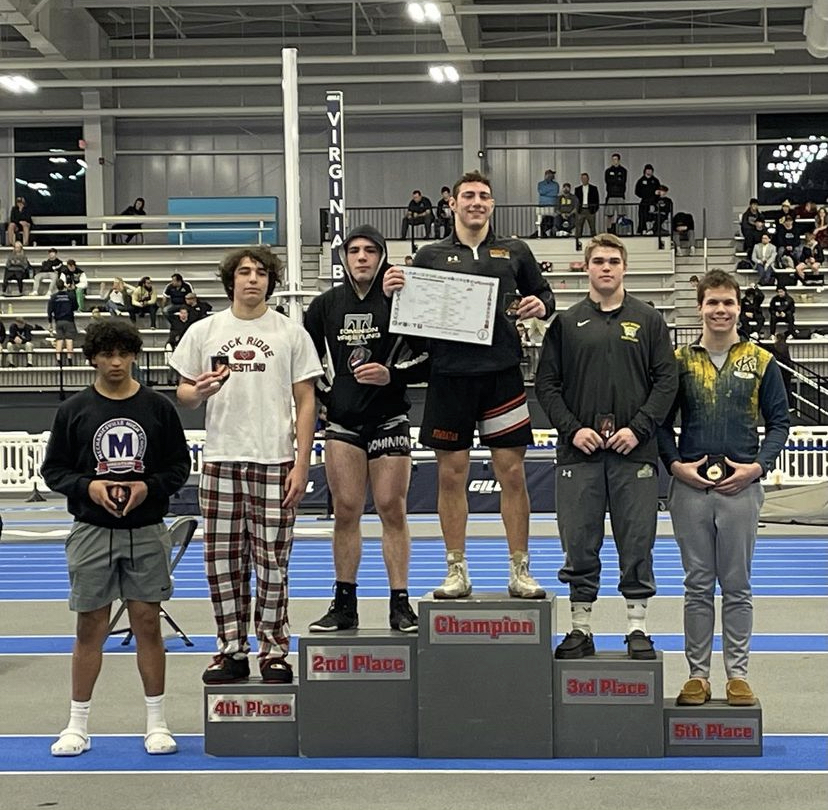 Junior Ilias Cholakis stands on the podium at states on Feb. 18 holding his fourth place medal. ¨I did pretty well -- improved from last year, which was my goal,¨ Cholakis said.