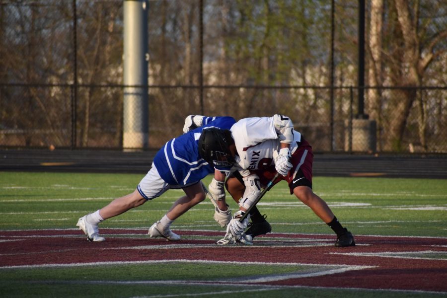 Sophomore Tyler Valdov (18) fights for the ball in a face off during the second half.