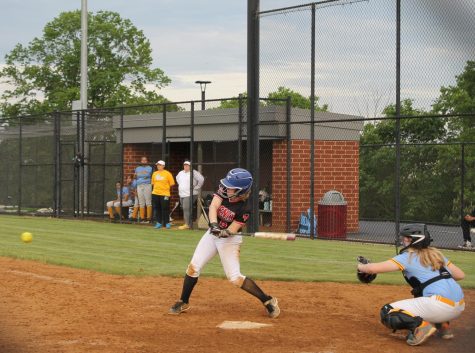 Junior Maddy Springer attempts to swing at the coming softball, allowing her team to advance to further bases on the field. “We should go in expecting to win and we need to have high hopes and good spirits,” sophomore Emma Spielman said.