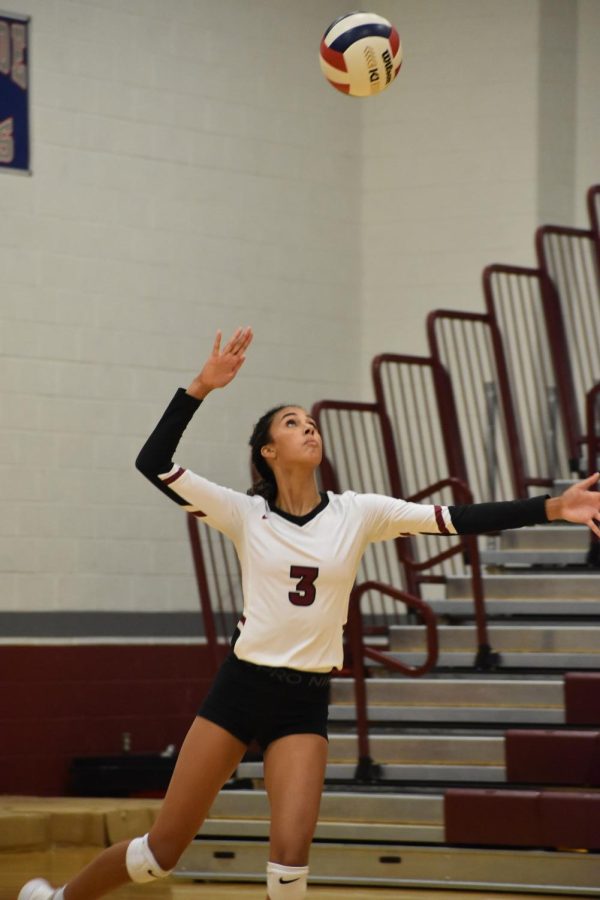 Junior+outside+hitter+Sidney+Powell+jumps+as+she+serves+the+ball+over+the+net+to+the+opposing+side.