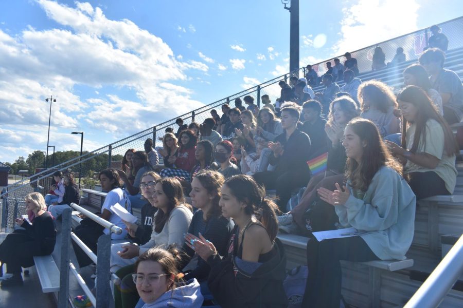 Holding pride flags and posters, students sit at the football field for a walkout in protest of recent educational guidelines from the VDOE that impacted transgender students.