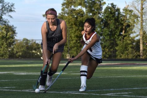 Senior and co-captain Harshroop Singh attempts to take the ball from the Titan opponent. “I think it’s crazy to see that I’ve learned a new sport just through the field hockey program here at Rock Ridge,” Singh said. “I’ve definitely seen a lot of improvement compared to previous years.” 