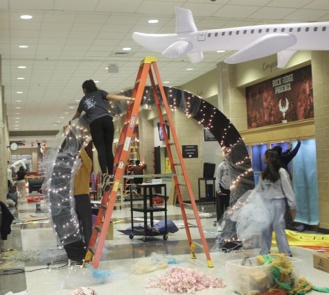 Student Council Association (SCA) members decorate a large arch for the Homecoming Dance before students arrive. The front entrance, gym, and cafeteria were transformed into city themed attractions on the morning of Oct. 22.