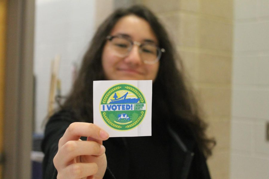 Senior Shaima Tora holds the “I Voted!” sticker that people in the state of VA receive after voting.  “Youre going to be the one who’s affected the longest, based on the policies and the people you vote in,” Tora said.
