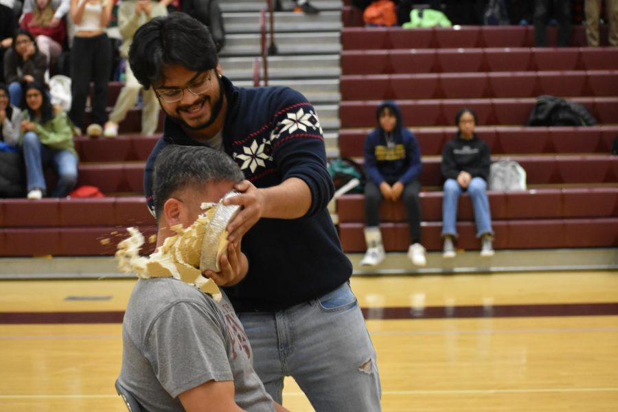 Economics teacher Peter Kim gets pied in the face by senior Akarsh Kontham, after gaining the most money from the hot chocolate sale.