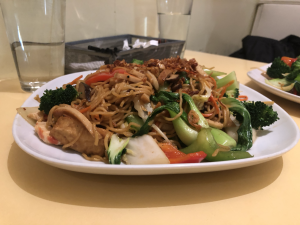 Loving Hut’s vegan stir-fried noodles feature broccoli, bok choy, and other assorted vegetables, as well as tofu and imitation shrimp as meat substitutes.