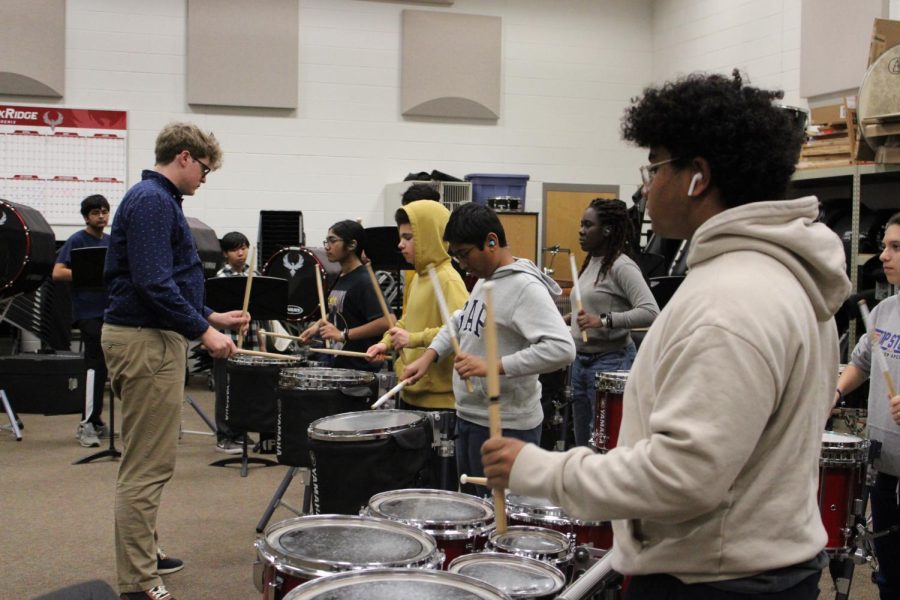 Winter Drumline director Patrick O’Rourke instructs members of the ensemble as they prepare to play one of their pieces. This was the first year that the Winter Drumline program was active, and O’Rourke hoped that they would reach a high standard of performance over time. “There’s lots of programs in other high schools, and we’re hoping to get to that level,” O’Rourke said. 