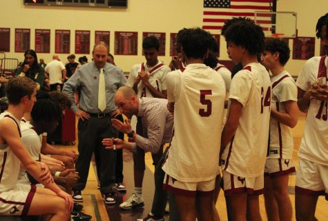 In the final moments of the boys varsity game, Phoenix coach Jay Geyer lays out a gameplan to lock the Spartans down on the defensive end of the court and prevent them from scoring.