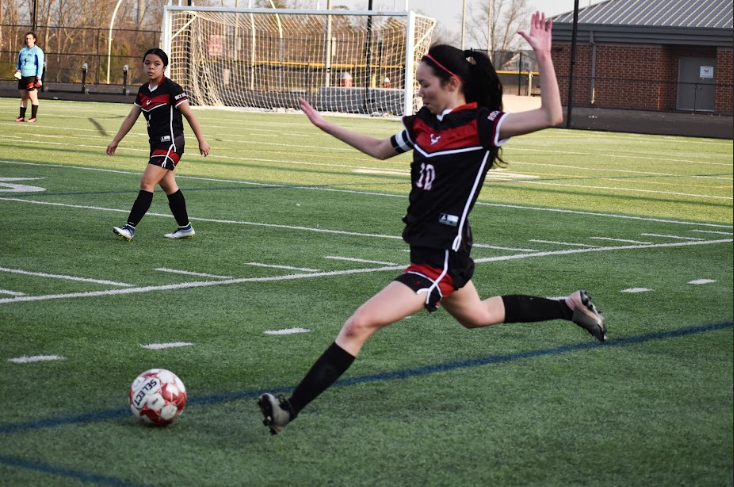 Junior Kim Trieu kicks the ball to her teammate further downfield, striving to get an assist. 