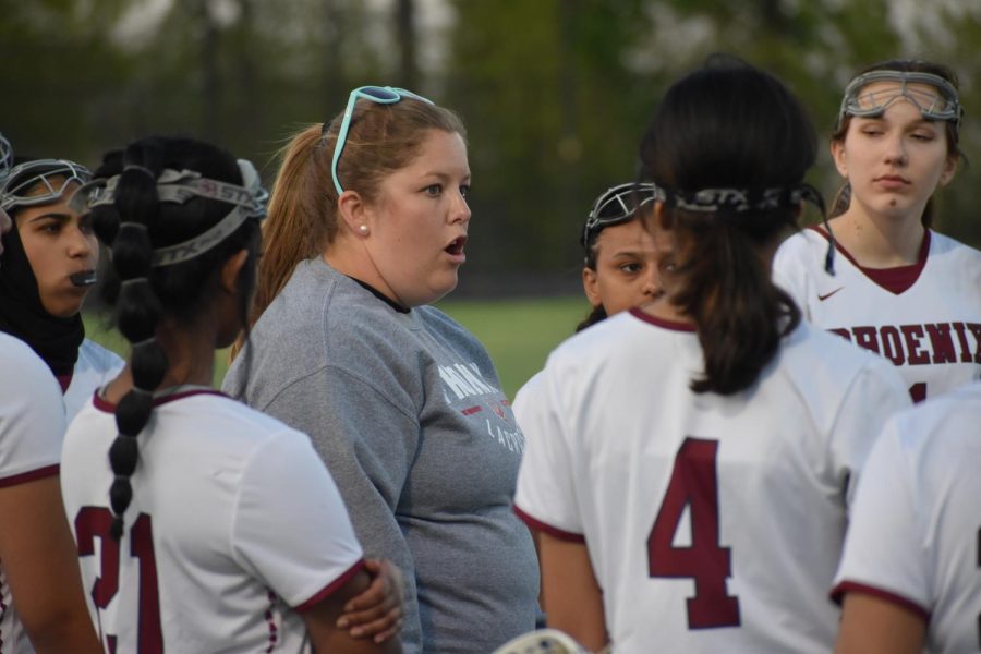 Jennifer Virbickis huddles up with her team to discuss the game plan during a timeout as the Phoenix took on the Stone Bridge Bulldogs on April 19.