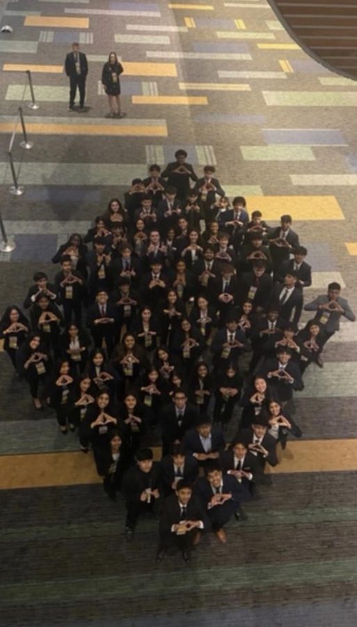 Before they leave the convention center, the DECA team meets to form the DECA symbol in a group photo. “It was really engaging, we got to meet a lot of different people and discover new skills,” junior Varsha Korumili said.