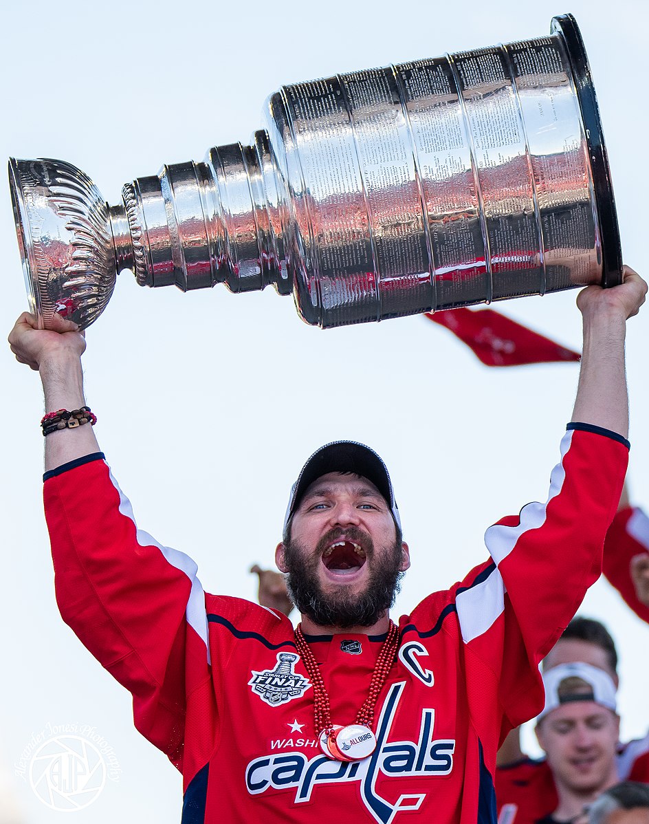 Celebrating a victorious end to his decade long hunt for the famed Stanley Cup, left winger and captain for the Washington Capitals, Alexander Ovechkin cheers on the celebrating fans at the championship parade in June of 2018. Simply known by many hockey fans as “Ovi,” Ovechkin has changed the game worldwide. Hailing from Russia, and largely known as one of the greatest players to ever play the sport (as he currently sits at number two on the all time goals scored list), he has single handedly grown the game in the D.C. Metropolitan area to unprecedented heights. Photo courtesy of Alexander Jonesi via Wikimedia Commons.