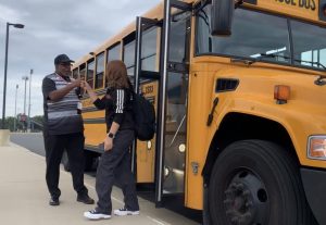 SPED Dean Jesse Hudson fist bumps sophomore Keira Bacas as she steps out of the school bus to begin her first day of school on Aug. 24. Teachers and students were excited to return back to school for Rock Ridges 10th year and were looking forward to starting the school year with new projects.  