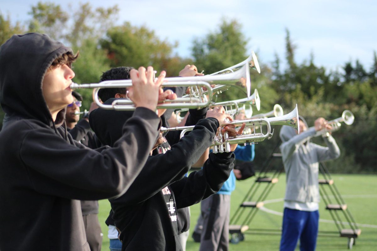 The trumpet section plays in a unified harmony at practice on Thursday, Oct. 19. They fine-tuned their synchronization to be prepared for competition on Oct. 21. “When there is energy in the show, you can definitely feel it,” senior Shoumik Bisoi said. 