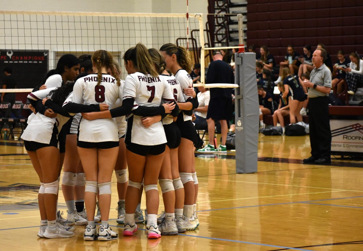 The Phoenix volleyball team gets into a group huddle to deliberate their next move.