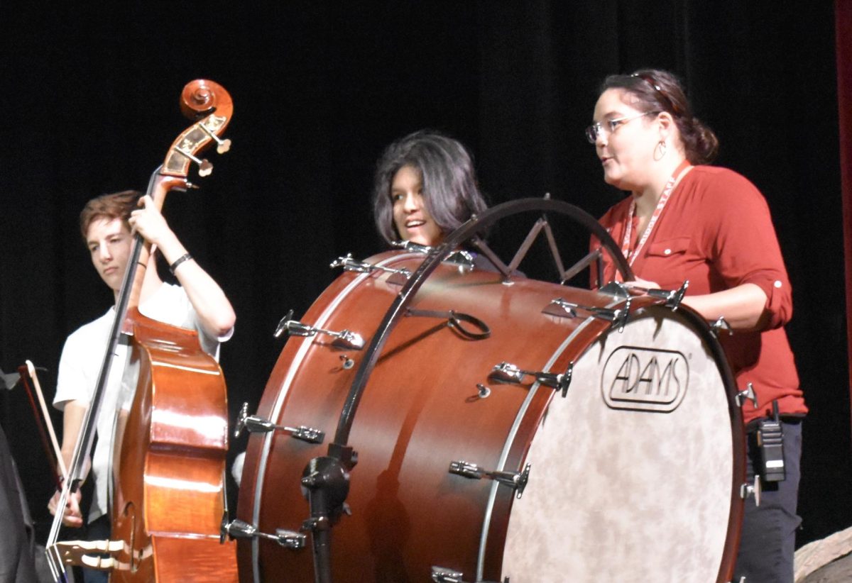 Math teacher Amy Holliday plays the bass drum along with sophomore Ambs Salazar-Lopez. As the orchestra and United Sound students performed multiple songs, orchestra director Teresa Gordon conducted them.