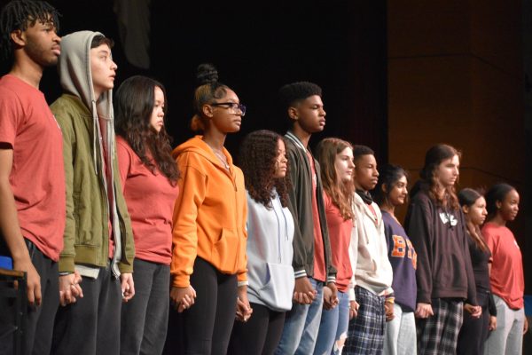 The Red Cast of “And” stands in a line before they take their final bow.