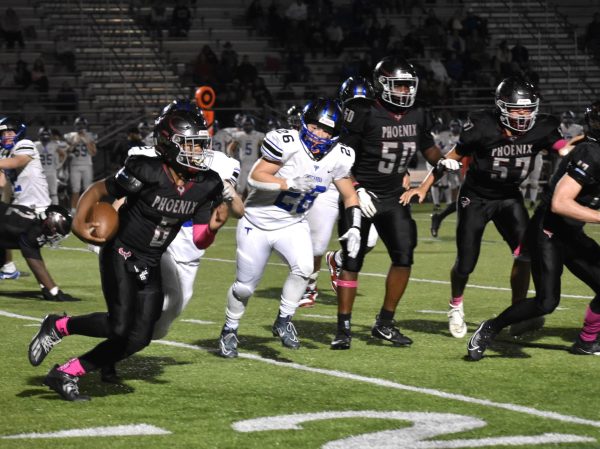 Sophomore Xavier Smith (6), the Phoenix quarterback, runs the ball as his teammates help hold up the defense. “My [offensive] line collapses, so I just [have to run], and its a good way to get first downs because [Tuscarora’s] defense was really good,” Smith said.
