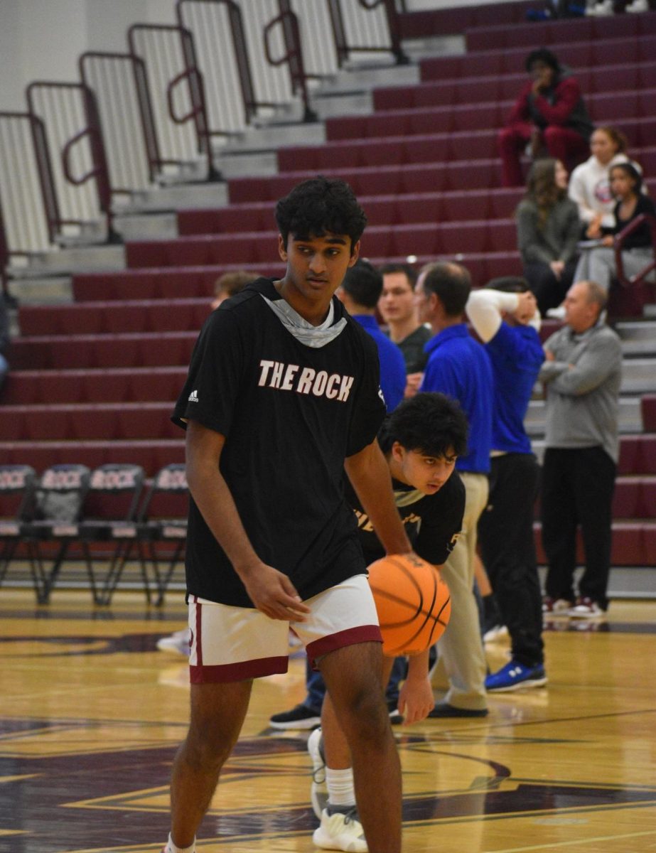 Dribbling the ball between his legs, sophomore Siddharth Donthireddy warms up for his game against the Lightridge Bolts. 
