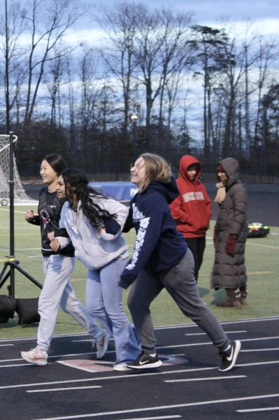 (left to right) Sophomore Jolyne Ma holds onto seniors Aishwarya Salur and Emily Spielman, both of whom are managers for the indoor track team. “As team manager, I just bring out the water, I time when I’m asked to, and set up hurdles during meets along with telling when the teammates were supposed to come over to the track,” Spielman said. Senior night was memorable for Spielman because she, and the other track manager Salur, walked each other down. 