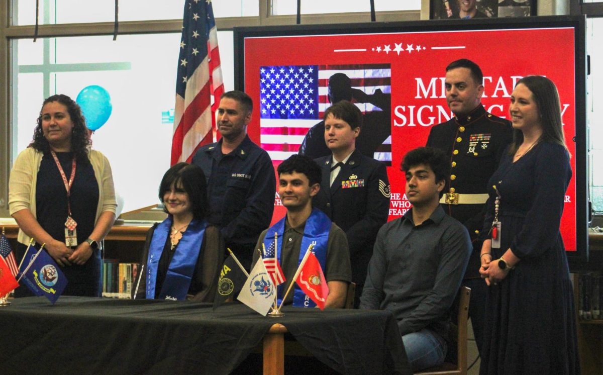 Seniors Elena Frisby, Jacobo Borgen, and Zalaan Khan (from left to right) along with their recruiters gather to commemorate their signing. “The military has great benefits, and I grew up in a military-style household, so I just felt that it was only right,” Borgen said. “I like to think of myself as disciplined and hardworking.”