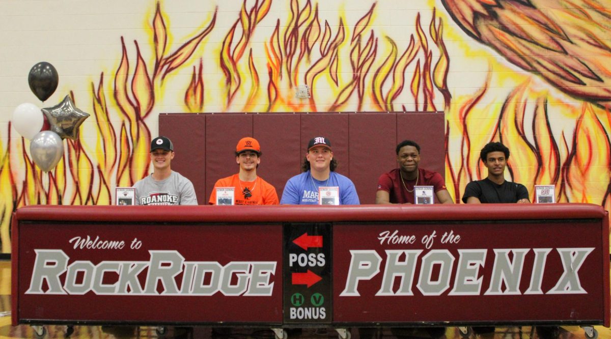 (From left to right) Seniors Austin Fisher, Dylan Neach, Paul Smith, Demarrius Stewart, and TeYany Kleiner sit together as their coaches, family members, and teammates wish them well in the next chapter of their sports careers.