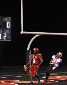 Senior running back Shamar Ferrell celebrating in the endzone after narrowly avoiding a Patriot player.