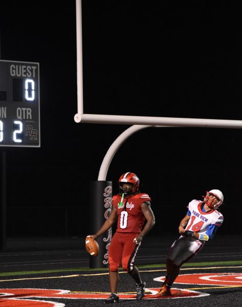 Senior running back Shamar Ferrell celebrating in the endzone after narrowly avoiding a Patriot player.