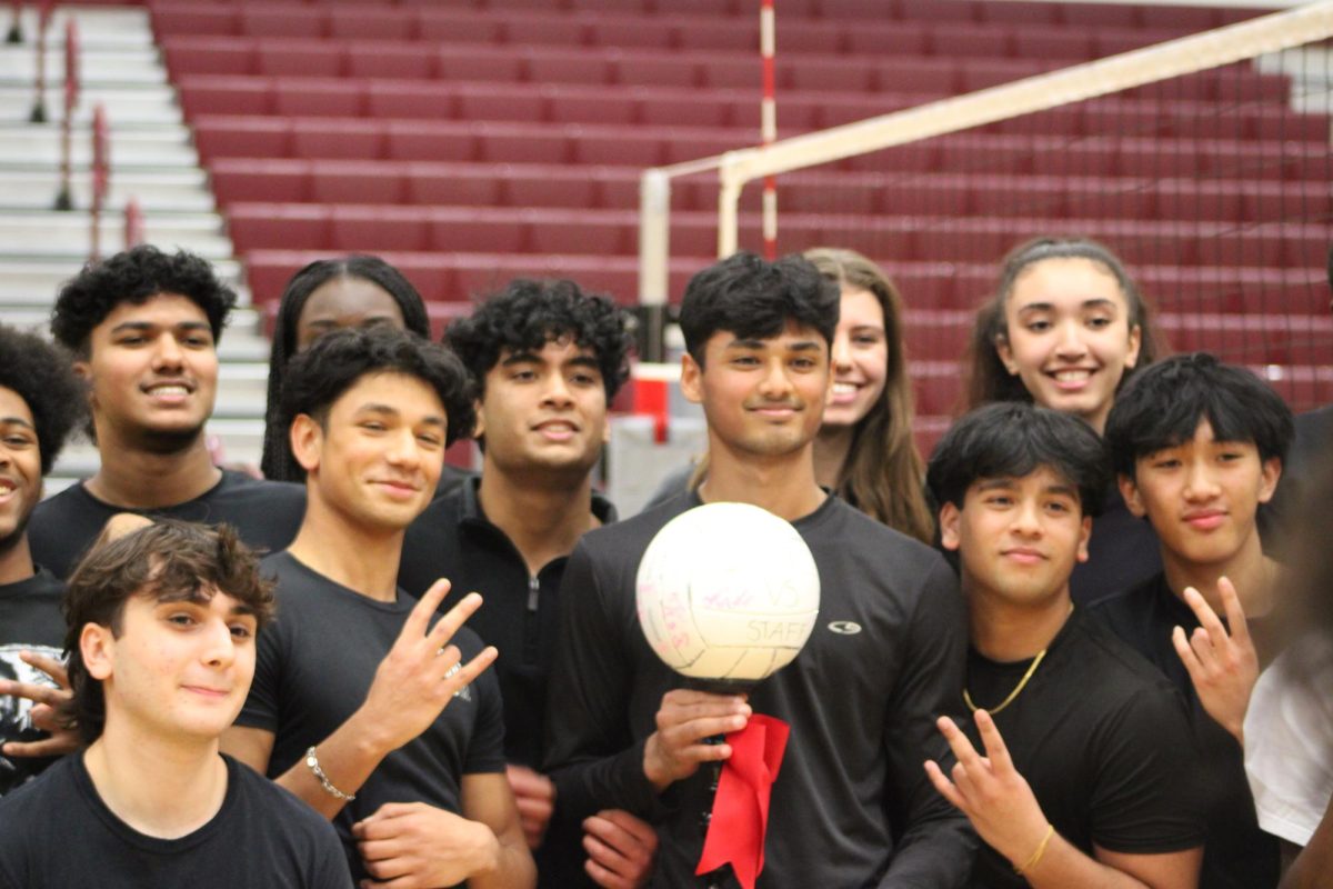 The student team poses after the game with the trophy, which they won after defeating the teachers 36-30.