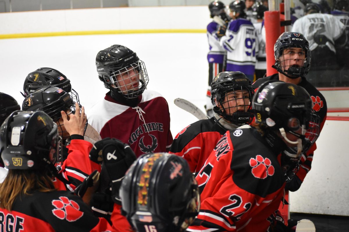 Phoenix/Heritage players meet at the bench to discuss the upcoming play with Coach David Bultema.