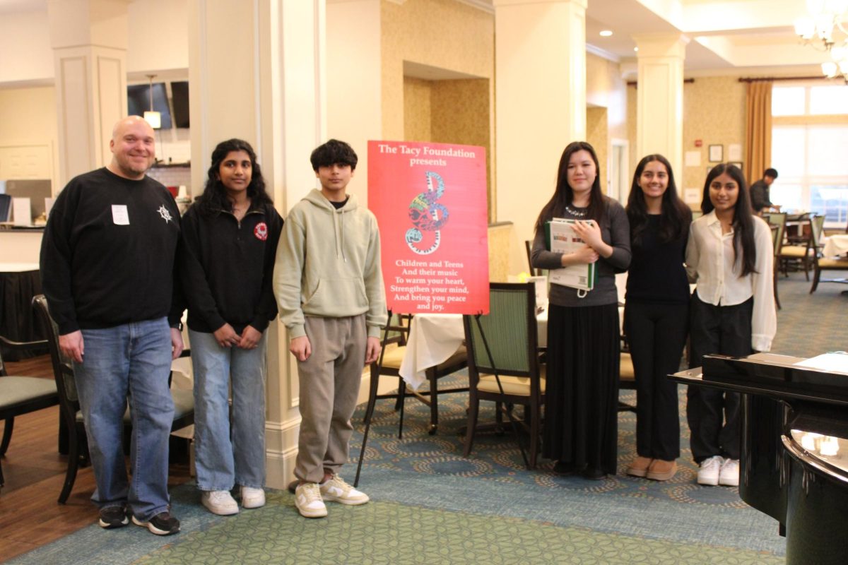 (From right to left) Choir Director Jordan Markwood, Thomas Jefferson High school sophomore Aashika Pesaladinne, Rock Ridge junior Yash Sahoo, Stone Bridge High School junior Audrey Lam, Riverside High School junior Navya Suri and senior Akira Dasgupta pose for a picture after their performance.  