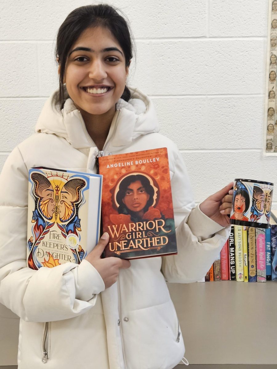 Sophomore Simone Nagpual poses with two signed copies of “Firekeeper’s Daughter” and a themed mug, gifts she received from best-selling author Angeline Boulley. 
Photo courtesy of Scott Schwarz 