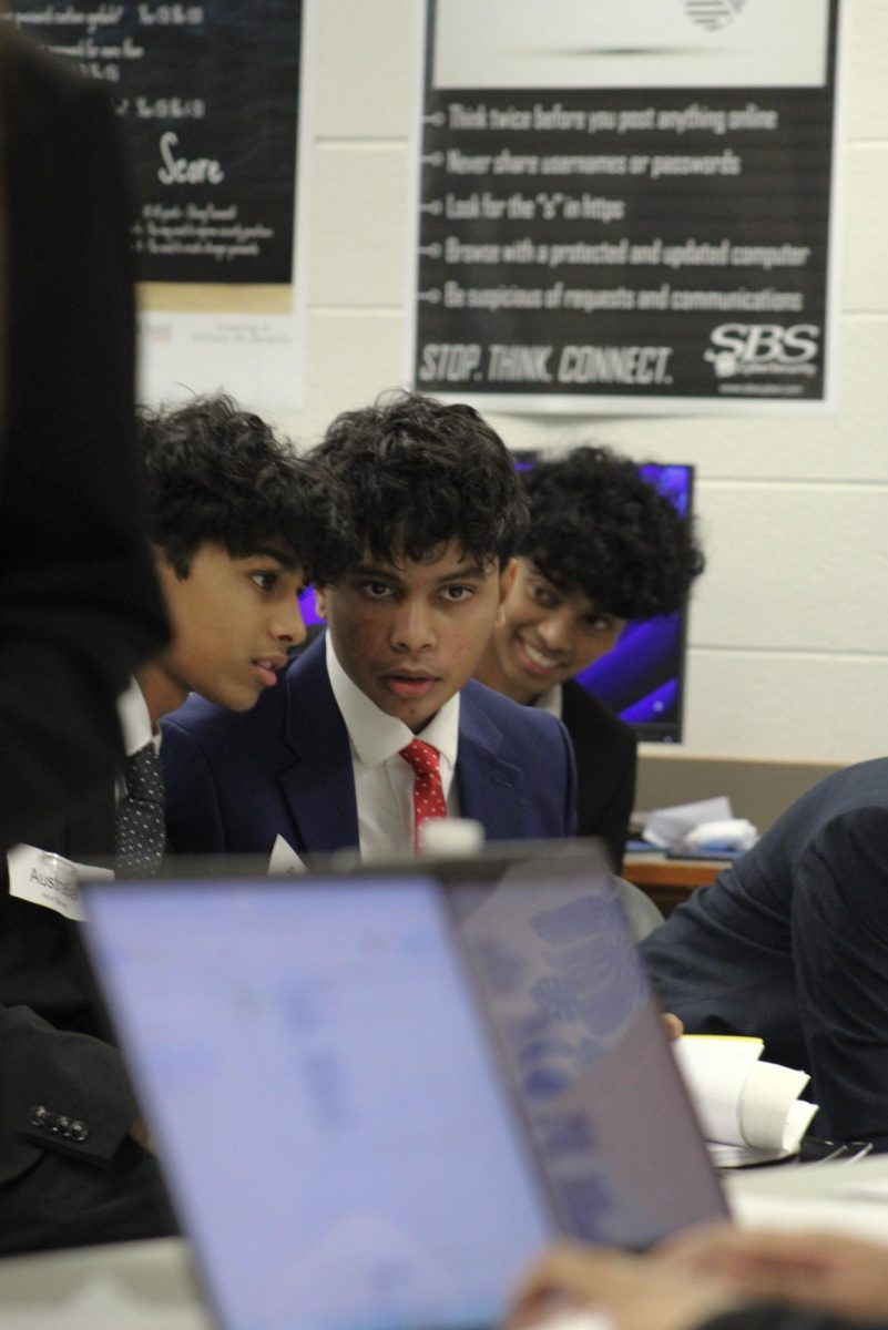 Two delegates in the United Nations on Drugs and Crime committee discuss their next plan of action immediately after a speech from another country. 