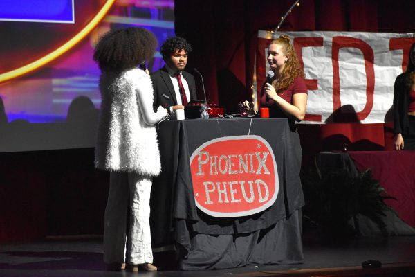 Team captains junior Angel Labosette and senior Sophie King, with host junior Shaun Sahayadarlin at the podium, prepare themselves to answer the presented question. 