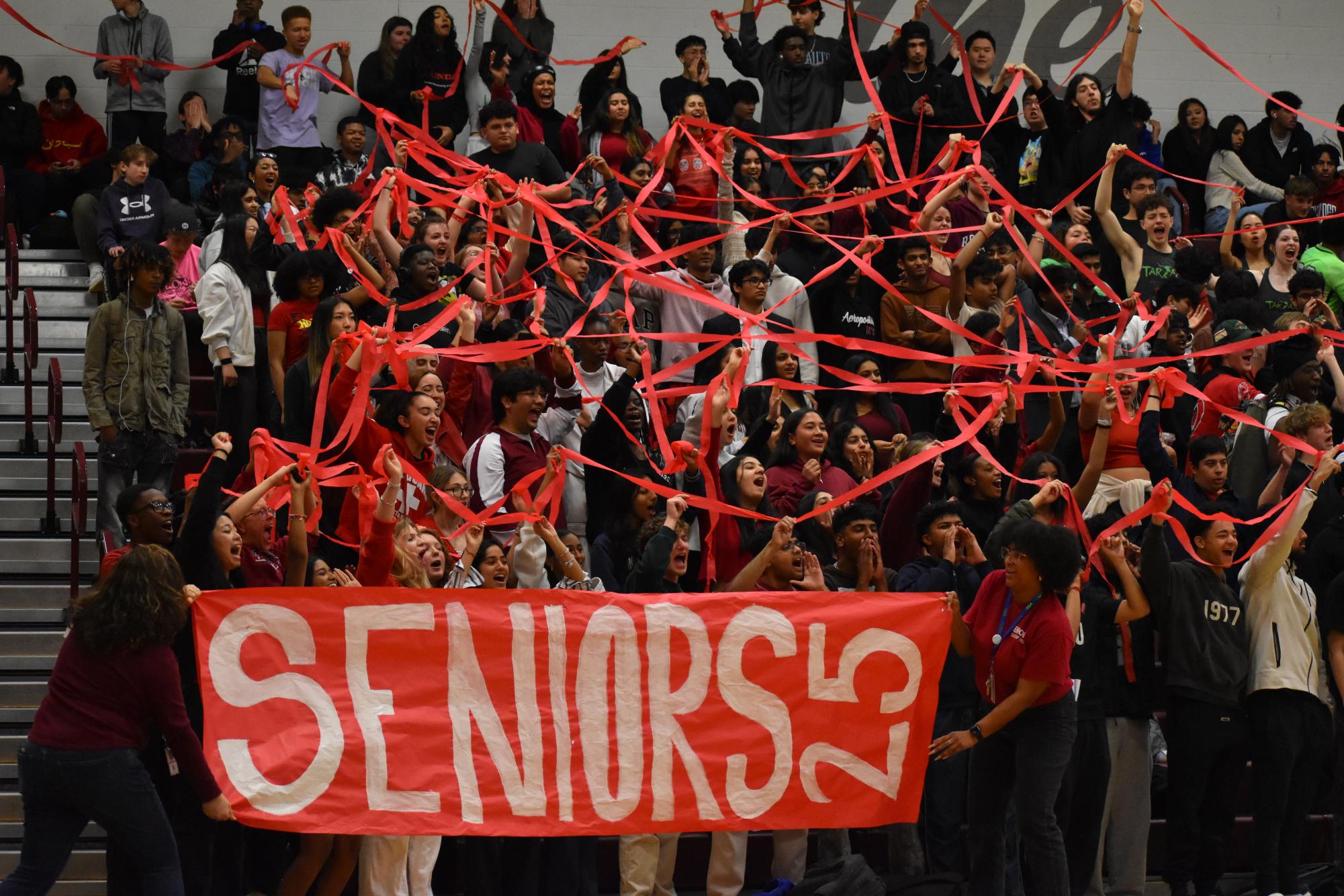 The senior class holds up red streamers, representing their class color, to attempt to win one of the pep rally games. 