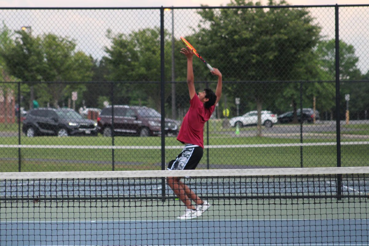 Freshman Karthik Uppalapati serves a ball during his singles match.