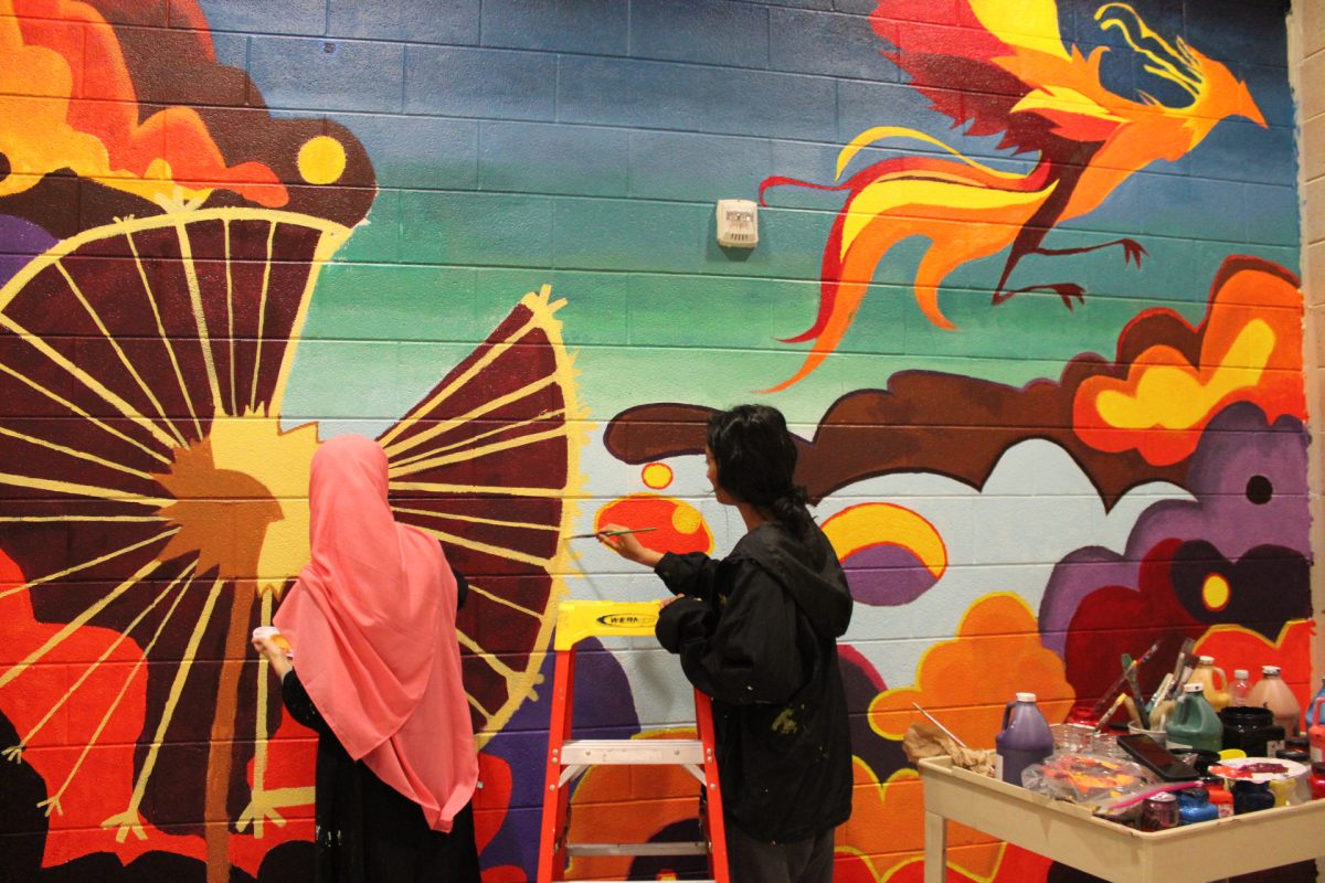 AP art students Nitya Matcha and Sitwat Mian paint their mural in the main hallway for their senior capstone.