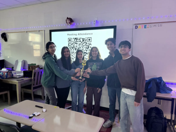 Students part of the Science Olympiad club hold their regional trophy, an award they haven’t won since 2014.