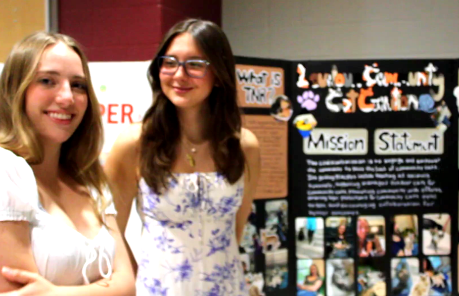 Two seniors engaging with other people  as they explain their capstone experience with the “Mission Statement” project. 