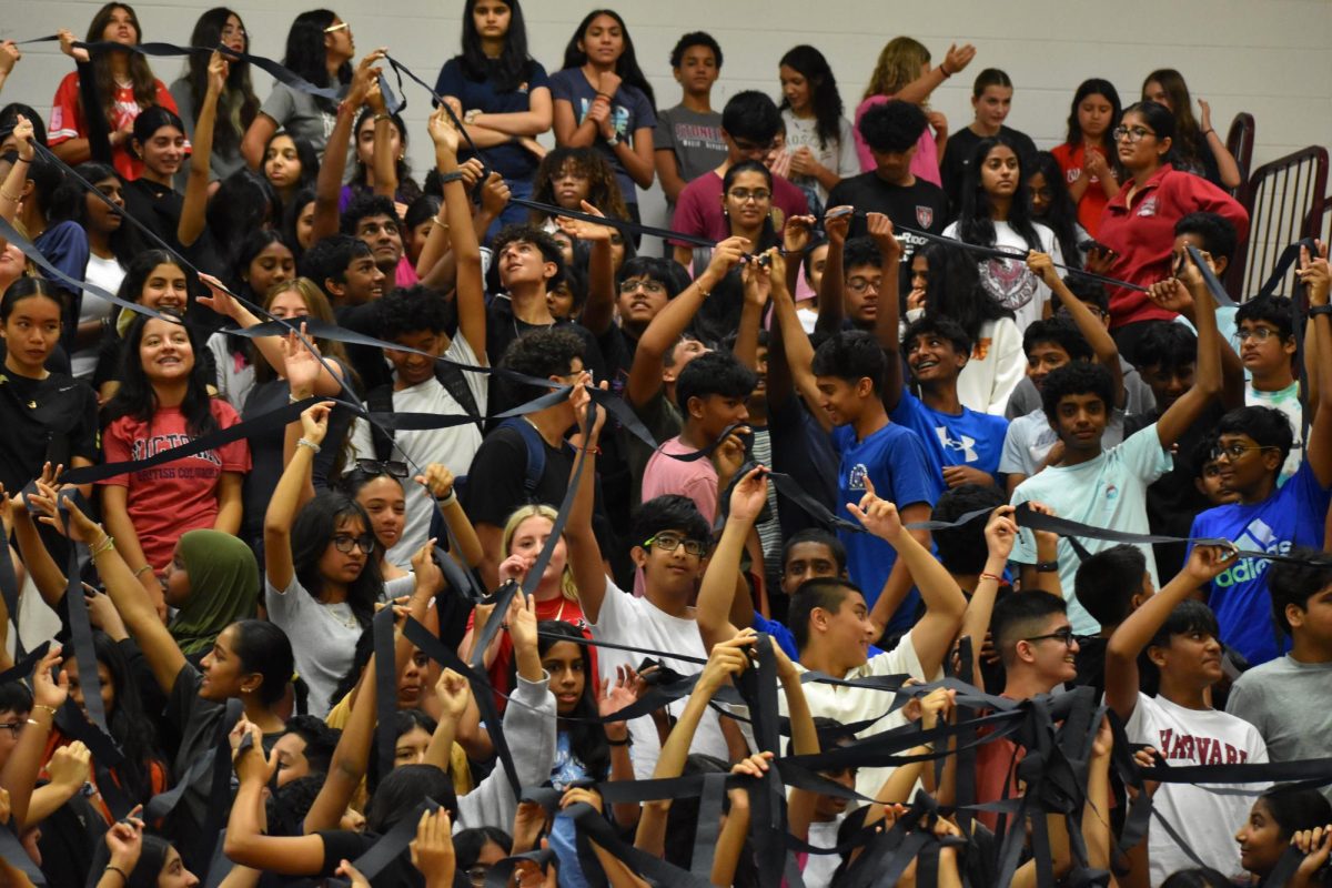 Freshmen participate in the streamer activity during the trial pep rally held at the end of orientation, where the goal was to unravel the streamer throughout the bleachers.